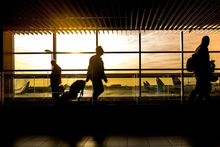 Travelers walking in an airport terminal during sunset, symbolizing the journey on an Indian eVisa.