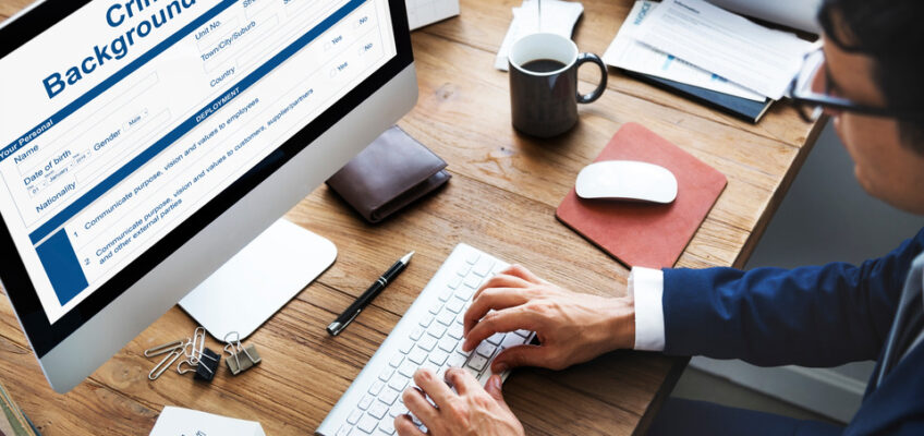 A person conducting an online criminal background check on a computer screen, possibly for a New Zealand eTA application.