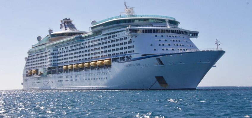 A large cruise ship sailing on a calm sea under a clear blue sky.