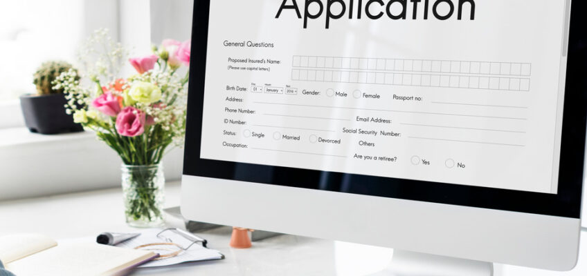 A computer screen displaying an application form with a person's hands visible, typing on a keyboard, indicating the process of filling out an eTA application online.