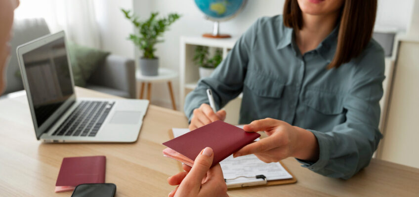 Travel consultant handing over a passport to a client during a Turkish eVisa application assistance session.