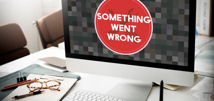 An office desk with a computer displaying an error message "Something went wrong", indicating technical issues, suitable for an article on the New Zealand eTA website problems.