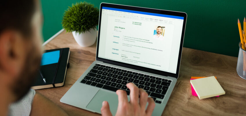 A person reviewing a professional resume on a laptop screen, possibly for updating personal details in preparation for completing the New Zealand eTA form.