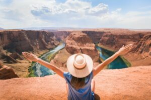 A traveler with outstretched arms facing the grandeur of Horseshoe Bend, symbolizing the freedom and exploration possible with a valid U.S. ESTA.