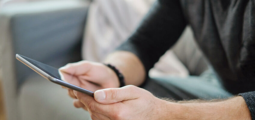 Man using a digital tablet, potentially to contact the Canada eTA authorities or seek travel information online.