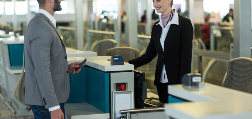 A traveler handing over his passport to an airport staff member at a boarding gate, illustrating the practical side of Canada's eTA security checks.