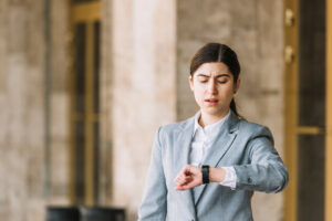 A concerned woman checking her watch, symbolizing the urgency and time sensitivity often associated with travel authorizations like the U.S. ESTA application process.