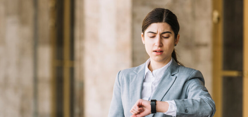 A concerned woman checking her watch, symbolizing the urgency and time sensitivity often associated with travel authorizations like the U.S. ESTA application process.