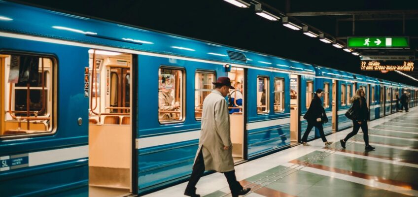 A bustling subway station with passengers alighting from a blue train and walking on the platform, indicating the movement of people which could involve crossing borders.