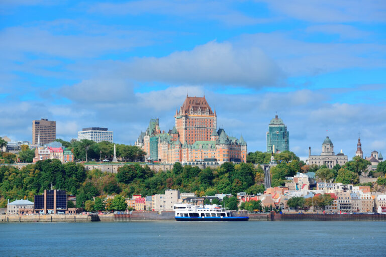 Picturesque Quebec City: Skyline reflected in the river, under a vibrant blue sky.